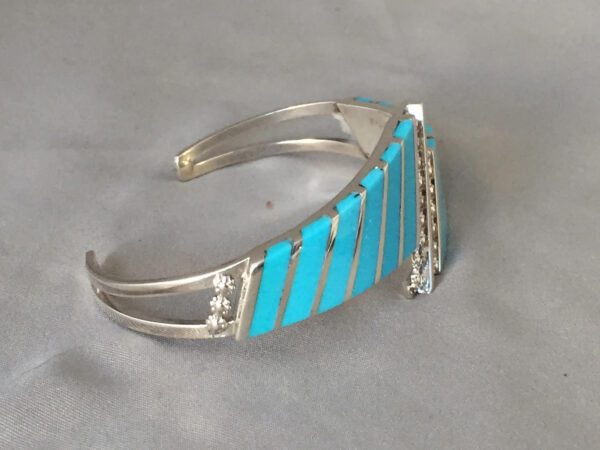 A Silver Color Bracelet With Blue Paint Lines