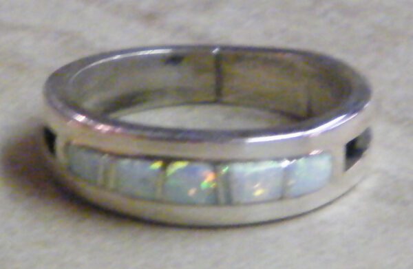 Zoom in view of mens wedding band, white opal muskett