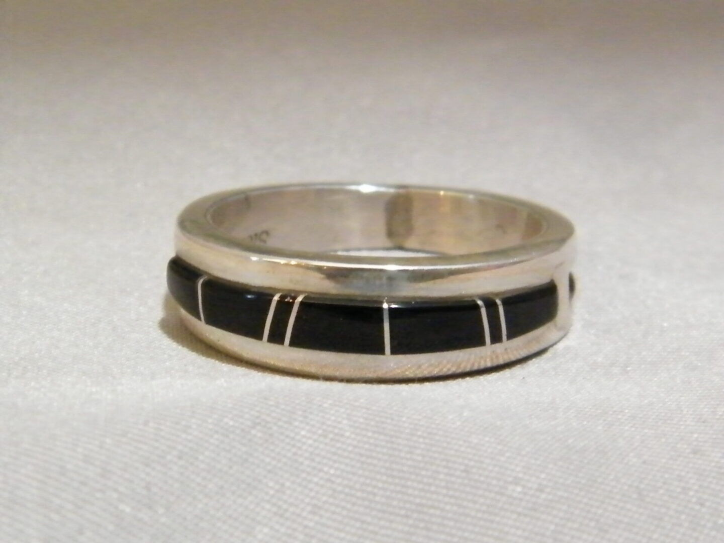 A Silver Ring With Black Stone and WHite Lines