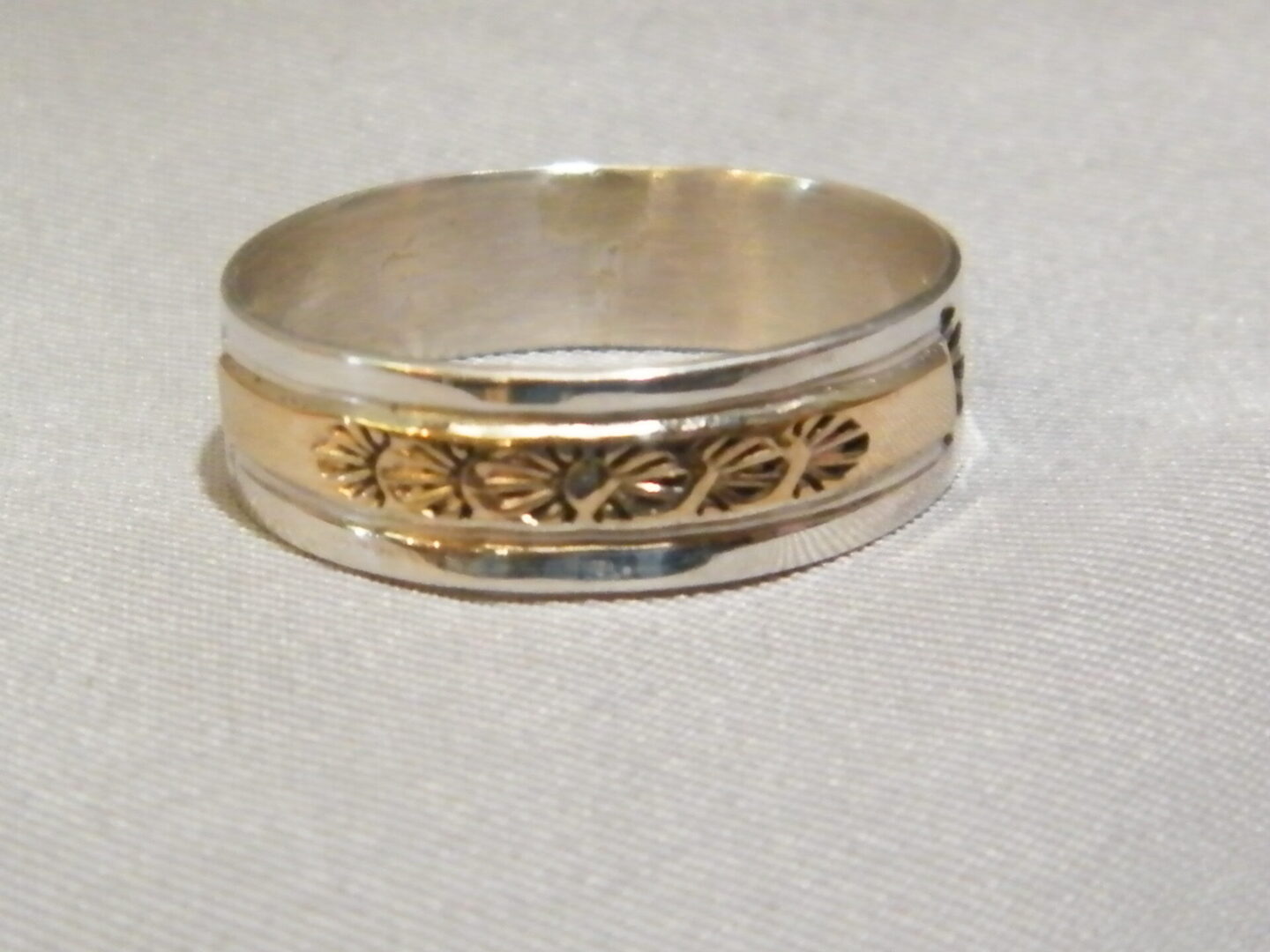 A White Gold Ring With Design in Center