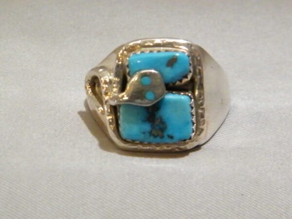 A Gold Ring With Blue Stone and Snake Pattern