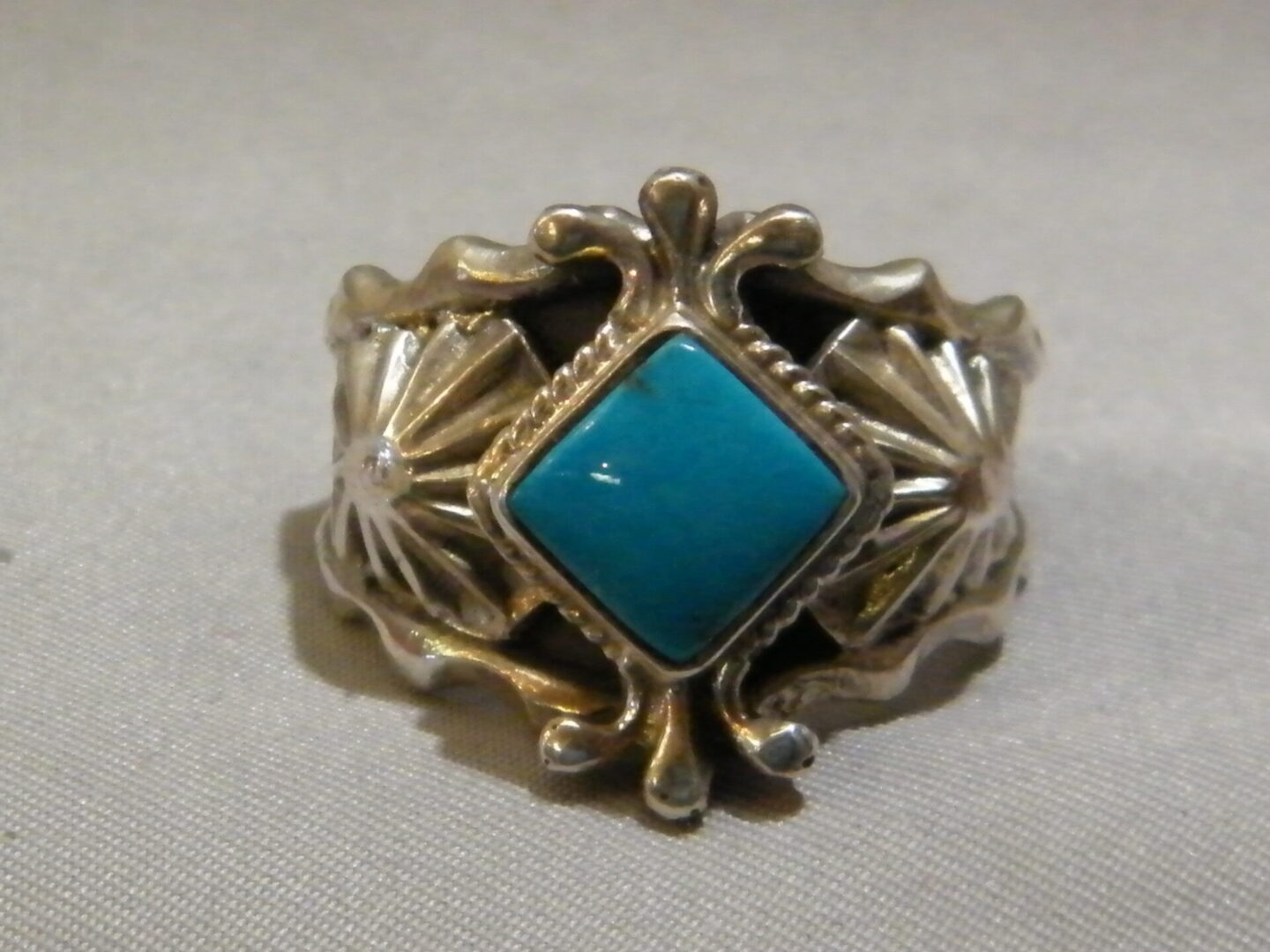A Gold Ring With a Diamond Shaped Blue Stone