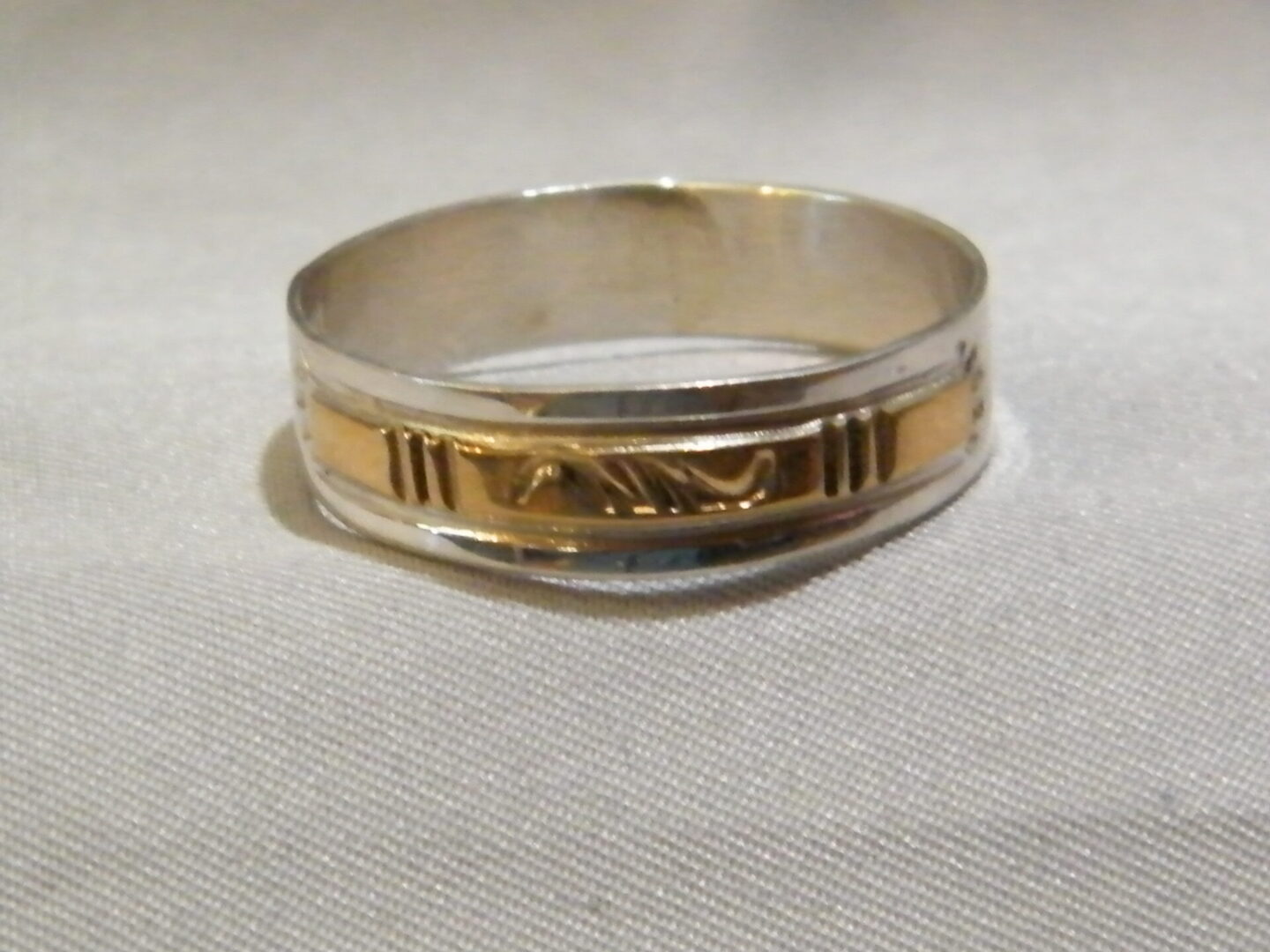 A Silver Color Ring With a Gold Band